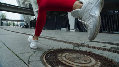 关闭女跑步者腿慢跑城市街运动女孩培训运行